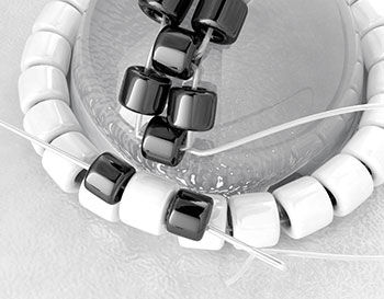 Needle passing through the last black bead into 2 black beads connected to a white bead